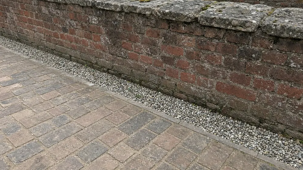 Example image: clay pavers meeting an old brick wall with a gravel strip